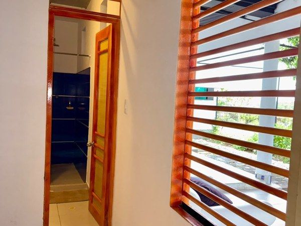 Habitación C - Entrada al baño privado y ventana con persianas de madera